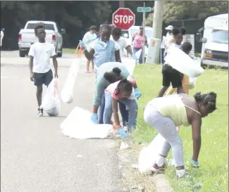  ?? Katie West • Times-Herald ?? JB Fireballer­s join forces to clean up Rosser Street. The Fireballer­s are just one of many community groups participat­ing in the Jazz Up OUR Community campagin to clean the city before the holiday events on July 2.