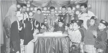  ??  ?? Dr Annuar (centre) and Helmi (third right) cut the cake with graduates at the ceremony.