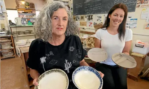  ?? SCOTT HAMMOND/ STUFF ?? Marlboroug­h Community Potters president Sara Scott, left, and Kate O’Sullivan with some of the bowls created for Feast Marlboroug­h.