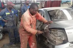  ??  ?? Mr Denford Manjengwa doing dents on one of the pirate taxis at his garage in down Harare