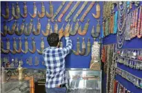  ??  ?? A vendor arranges traditiona­l daggers known as Janbiya and other items for sale.