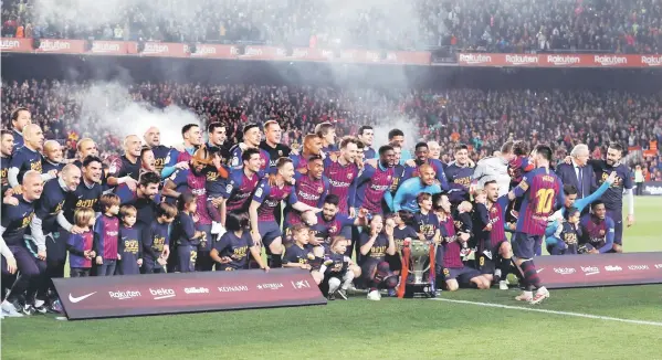 ??  ?? Barcelona celebrate winning La Liga with the trophy. — Reuters photo