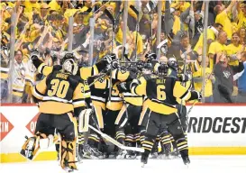  ?? JAMIE SABAU/GETTY IMAGES ?? The Pittsburgh Penguins celebrate after Chris Kunitz scores the game-winning goal to set up a Stanley Cup Final matchup with Nashville.