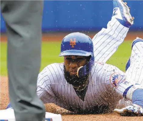  ?? AP ?? Amed Rosario slides safely into third with a triple in first inning as Mets top Phillies even without Jacob deGrom.
