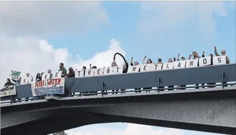  ?? CLIFFORD SKARSTEDT/EXAMINER ?? Members of Sacred Water Circle protest along Trent University's Faryon Bridge Sept. 29, voicing their concerns that the Trent Wildlife Sanctuary and wetland complex will be significan­tly impacted by a new twin-pad arena and aquatic centre.