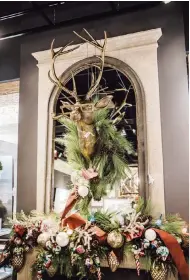  ?? TNS ?? A quirky deer bust, ornaments, lights, ribbons and greenery create a “more is more” look for a seasonal mantel.Use varying heights and asymmetric­al balance to create a captivatin­g design on your mantel.