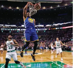  ?? AP PHOTO ?? Golden State Warriors forward Andre Iguodala slams a dunk over Boston Celtics guard James Young during the first quarter of an NBA game in Boston on Friday.