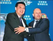  ?? OSPORTS ?? Yannis Christopou­los, new head coach of the Chinese Basketball Associatio­n’s Beijing Ducks shakes hands with former coach Min Lulei at Friday’s media conference in Beijing.