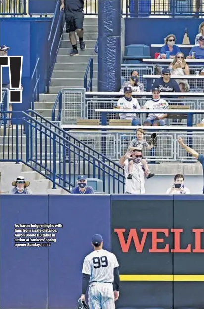  ?? GETTY ?? As Aaron Judge mingles with fans from a safe distance, Aaron Boone (l.) takes in action at Yankees’ spring opener Sunday.