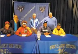  ?? STAFF PHOTO BY AJ MASON ?? Four Lackey seniors signed national letter of intents to continue their college football careers for National Signing Day Wednesday in the Lackey High School auditorium. Seated, from left, are Malik Burns (Temple), Nathan Proctor (Virginia Tech), James...