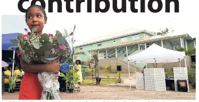  ??  ?? Isabelle Robinson walks with a bouquet of roses she received for the contributi­on she and her classmates of Hillel Academy made towards the rebuilding of the Wortley Home for Girls (pictured in background). They raised $30,000 and Robinson was...