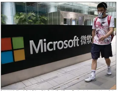  ?? (AP/Ng Han Guan) ?? A man passes the Microsoft office in Beijing on Friday. President Donald Trump on Thursday ordered a sweeping but unspecifie­d ban on dealings with the Chinese owners of consumer apps TikTok and WeChat.