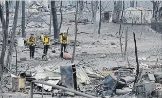  ?? MARCIO JOSE SANCHEZ THE ASSOCIATED PRESS ?? Firefighte­rs assess the damage on Sunday to a neighbourh­ood in the aftermath of a wildfire in Keswick, Calif.