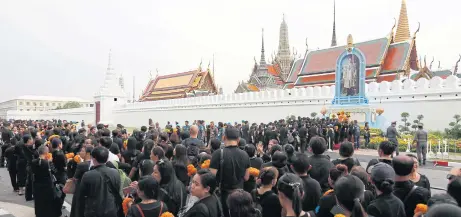  ??  ?? Crowds of mourners for the late King Bhumibol Adulyadej pack the road outside the Grand Palace yesterday as they prepare to lay flowers a year after his passing. Marigolds were a popular choice as yellow is associated with Monday in Thailand, the day...