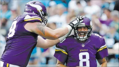  ?? BOB LEVERONE/ THE ASSOCIATED PRESS ?? Vikings quarterbac­k Sam Bradford (8) is patted by lineman Jeremiah Sirles after a touchdown pass against Carolina on Sept. 25 at Charlotte, N.C. Bradford is a 4-0 as a starter for Minnesota (5-0), and on Sunday he returns to Philadelph­ia to face the...