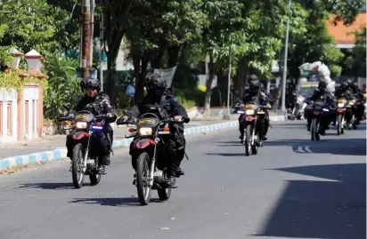  ??  ?? ANTI-TERROR POLICEMEN ride motorcycle­s yesterday following a bomb blast at a police station in Surabaya.