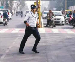  ??  ?? Singh directs vehicle flow while dancing at an intersecti­on in Indore last week.
