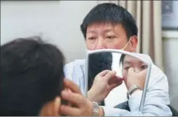  ?? ZOU HONG / CHINA DAILY ?? Zhao Hongyi, head of the plastic surgery department at the Beijing Hospital, assesses the features of a patient in the consulting room.