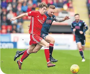  ??  ?? Aberdeen’s Ryan Christie and Ross County’s Craig Curran go after the ball