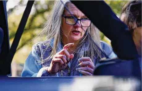  ?? Brynn Anderson/Associated Press ?? Jessie Blanchard shows a participan­t how to use a straight pipe as she hands out other goods like food, naloxone, needles, tourniquet­s and condoms to members of the community on Jan. 23 in Albany, Ga. The nurse operates 229 Safer Living Access.