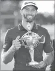  ?? Frank Gunn ?? The Associated Press Dustin Johnson holds the Canadian Open championsh­ip trophy Sunday after winning the tournament at Glen Abbey Golf Club.