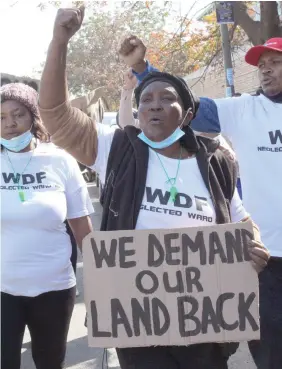  ??  ?? Residents of ward 19 hold a placard with their grievances.