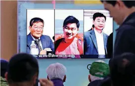  ?? [AP PHOTO] ?? In this May 3 photo, people watch a TV news report on screen, showing portraits of three Americans, Kim Dong Chul, left, Tony Kim and Kim Hak Song, right, detained in the North Korea, at the Seoul Railway Station in Seoul, South Korea.