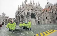  ??  ?? Municipal workers wade past St Mark’s Basilica