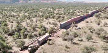  ?? — AFP ?? A truck drives away with a shipping container removed from a long row of those stacked to create a wall between the US and Mexico.