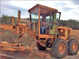  ??  ?? Joe Dickson sits in a modern grader equipped with things his first grader lacked, like hydraulics, an automatic transmissi­on and air conditioni­ng. (Photo by Buster Brown)