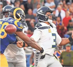  ?? TNS ?? Rams linebacker Dante Fowler forces a fumble by Seattle Seahawks quarterbac­k Russell Wilson.