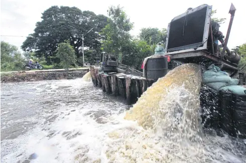  ??  ?? STEMMING THE FLOW: A pump siphons water from the flooded Decha Patthana 87 residentia­l community into a nearby canal in Pathum Thani’s Thanyaburi district.