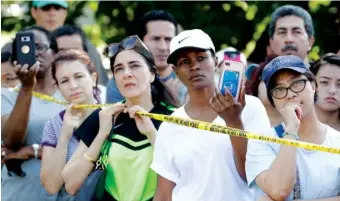  ?? THE ASSOCIATED PRESS ?? Residents listen to officials at a roadblock in their Canyon Gate neighborho­od, which was flooded Saturday when the Barker Reservoir reached capacity in the aftermath of Harvey in Katy, Texas. Residents gathered at the checkpoint to vent their...