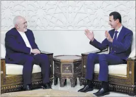  ??  ?? The Associated Press In a photo released by the Syrian news agency SANA, Syrian President Bashar Assad, right, speaks with Iranian Foreign Minister Mohammad Javad Zarif on Monday in Damascus.