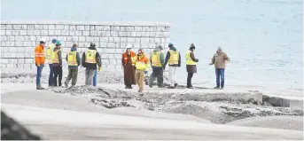  ??  ?? Crews on Friday survey the shoreline property that partially collapsed into the Detroit River to test for possible contaminat­ion from uranium radiation. RYAN GARZA/DETROIT FREE PRESS