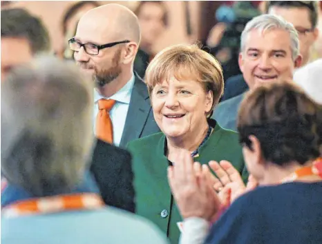  ?? FOTO: DPA ?? Von der CDU-Basis bejubelt: Angela Merkel in Heidelberg bei der Regionalkk­onferenz, rechts im Hintergrun­d Partei-Vize Thomas Strobl.