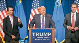  ?? —AP ?? Republican presidenti­al candidate Donald Trump, center, speaks as his sons Donald Trump, Jr., left and Eric look on during a caucus night rally.