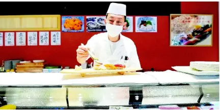  ?? AP ?? A sushi chef prepares a plate at the Toyosu Market on Monday, January 29, in Tokyo. Japan has slipped to the world’s fourth-largest economy as government data released yesterday showed it fell behind the size of Germany’s in 2023.