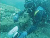  ??  ?? A diver holds a bowl with Chinese writing from one of the wrecks — AFP