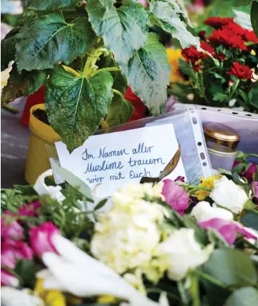  ?? Foto: dpa/Daniel Reinhardt ?? Blumen und Kerzen vor dem Supermarkt in Hamburg-Barmbek
