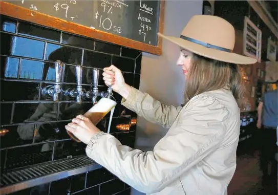  ?? Barbara Davidson Los Angeles Times ?? BARTENDER Kerry Vasquez fills a beer glass at Bar Covell, a wine bar with eight craft beer taps that is located near the Vermont / Sunset Metro Red Line station.