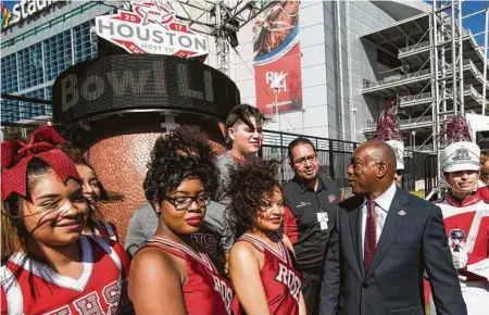  ??  ?? El alcalde de Houston, Sylvester Turner, habla con un grupo de estudiante­s de la preparator­ia Waltrip High School frente al cronómetro ubicado frente al NRG Stadium para el Super Bowl LI.