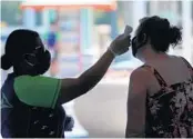  ?? JOE BURBANK/ORLANDO SENTINEL ?? A woman gets her temperatur­e taken before attending a SeaWorld event.