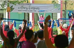  ??  ?? Kampung style: Residents taking part in a mass morning exercise at a wellness kampung at Block 765 in Nee Soon Central, Singapore. — The Straits Times/Asia News Network