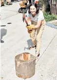  ?? ?? ▲ Teresa Machan plants an axe in wood (under supervisio­n) at the Kura