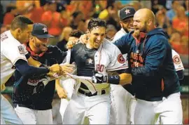  ?? Scott Halleran Getty Images ?? JASON CASTRO is mobbed by Astros teammates after hitting a home run against the Angels. Castro, now an Angel, played for Houston from 2010 to 2016.