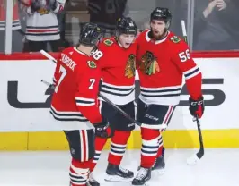  ?? | KAMIL KRZACZYNSK­I/ AP ?? Blackhawks defenseman Erik Gustafsson ( right) celebrates with Patrick Kane and Brent Seabrook after scoring his first goal of the season.