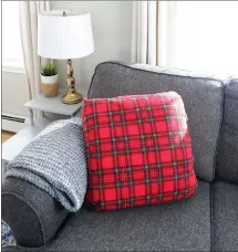  ??  ?? Heather bought red plaid fleece and wrapped it around a throw pillow, pinning it at the back. After Christmas, she isn’t stuck with a holiday pillow to store all year long.