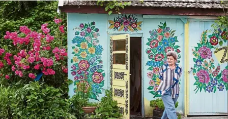  ??  ?? Floral splendour: Chlastawa strolling along her yard, where the walls of various buildings are covered with traditiona­l flower patterns in Zalipie, southern Poland. — AFP