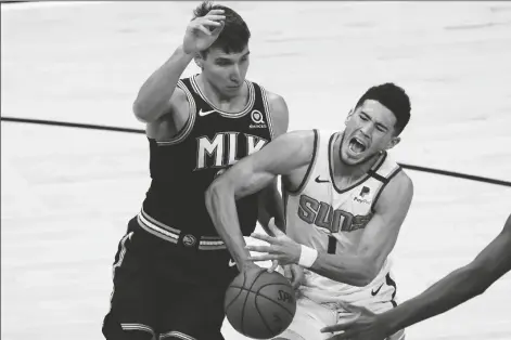  ?? JOHN BAZEMORE/AP ?? PHOENIX SUNS GUARD DEVIN BOOKER (1) is fouled by Atlanta Hawks forward Danilo Gallinari (8) in the first half of a game Wednesday in Atlanta.